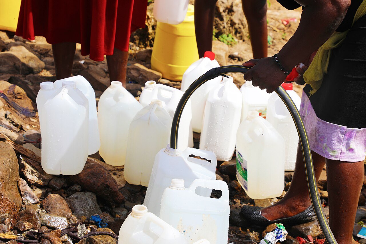 Water containers being filled from a hose in Mathare, Nairobi; representative water-access photography.
